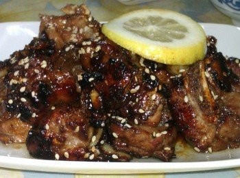 step2: 先以一大匙油熱鍋，然後將蒜片爆香，醃漬過後的小排放入鍋中以中火香煎不時翻面至熟透，最後淋上蜂蜜翻炒一下起鍋擺盤，灑上芝麻再擠些檸檬汁增加香氣，另一片檸檬則為裝飾~