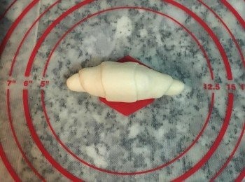 step14: 再輕輕滾起,包起起司後,兩手要輕壓在兩邊,慢慢往前推,即可滾成小牛角樣.