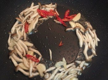 step5: 接著鍋中放入大蒜片,和秀珍菇或葷菇,和辣椒拌炒,直到微金黃色.