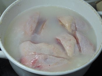 step3: 再加入適量的水與兩大匙酒與適量的鹽巴，並鋪上雞腿切塊，蓋上鍋蓋，用小火煮20分鐘