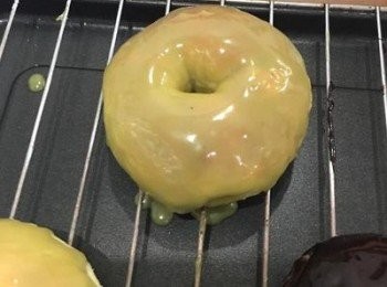 step6: 待甜甜圈略微降溫後便可直接表面朝下進行沾附的動作,亦可將甜甜圈放於網架上,下方墊鋁薄紙,將巧克力醬淋下.