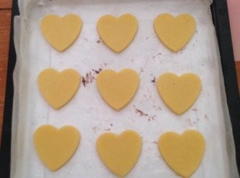 step4: 把雪好的麵團取出，要在檯面上灑些麵粉，放上麵團擀成約0.6cm厚的麵片，用心型模具吸出小麵片，排放入烤盤中，再放入冰箱冷藏15分鐘。