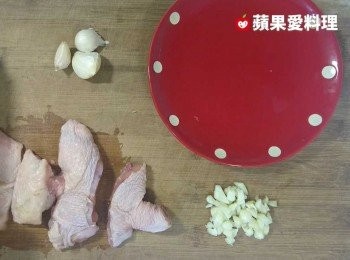 step1: 將3瓣蒜頭用刀背輕拍，去皮，切碎（另外3瓣蒜頭保留整顆，不去皮，不切）。雞腿切塊。