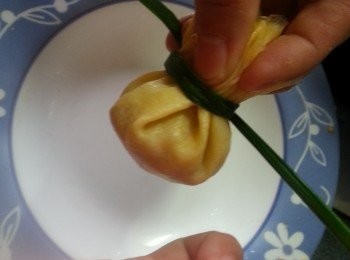 step20: 用手取起福袋,再用1條韭菜圍起打結(此動作要輕手,否則蛋皮會穿,韭菜會斷)