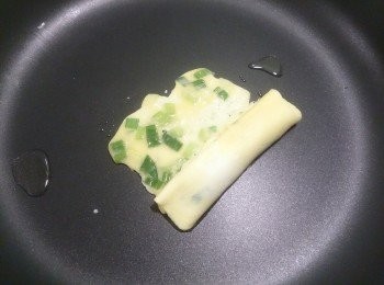 step3: 接著最尾端再放一湯匙的蛋液，於捲起來的蛋捲等長度呈長方形，等底部的蛋液可以翻動再捲起