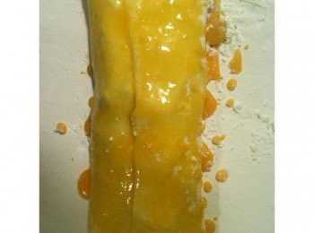 step7: 將捲皮的另一邊往中間折過來，用湯匙挖取蛋液，塗滿捲皮表面。