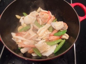 step4: 爆香後再加入甜碗豆和中捲及鮮蝦,以中大火炒至8分熟(蝦肉及中捲變色即可),先將海鮮起鍋裝盤放一旁備用。