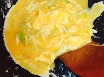 step3: 同一隻鑊加入一湯匙油，燒熱後先放入韮黄炒香，轉小火倒入蛋漿，用鑊鏟背面以推的手勢將蛋漿從鑊邊推向中央。