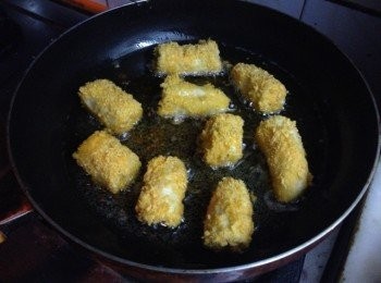 step4: 鍋裡放入適量的油，燒至6成熱，開小火，把香蕉段放入，慢慢炸至兩面都金黃