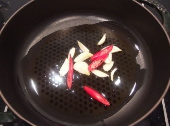 step3: 鍋子加入一匙橄欖油,放入辣椒及薑片,小火煸出香氣。