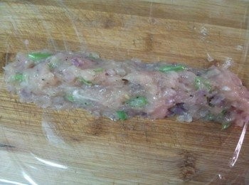 step7: 桌子上鋪上一張乾淨的保鮮膜 , 把一半雞肉泥放上 , 再鋪另一張保鮮膜繼續做另一條