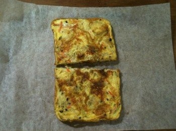 step5: 將步驟1的料理紙放在砧板上，再將步驟4的鮮蔬雞肉蛋放上，對切，兩人份鮮蔬雞肉蛋也完成了。