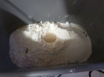step2: 然后加入面粉,盐和糖分别放在不同角落 ,在面粉上戳一个小洞放酵母。以「行程」鍵選擇行程基本麵包，烧色=浅色，再按下「開始」鍵。