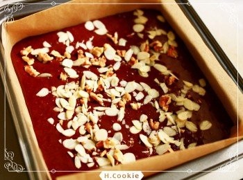 step5: 蛋糕模鋪上烘焙紙，再將麵糊倒入烤模，最後撒上杏仁片及切丁的核桃