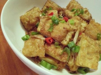 step2: 倒入橄欖油，先放入薑絲爆香，再接著放豆包小炒一下，看豆包呈金黃色有沒有偏軟，加點少許醬油，再放入辣椒和蔥珠小炒一下，並加入糖、香油後，即可呈盤上桌。