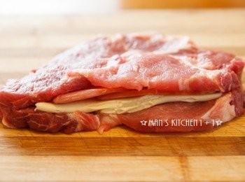 step3: <span class="group_1">食材</span>跟鍋具都準備好了以後再來我們要開始料理了，首先我們先將豬排從中間切出一個缺口後，把準備好的起司片與火腿塞入豬排當中。