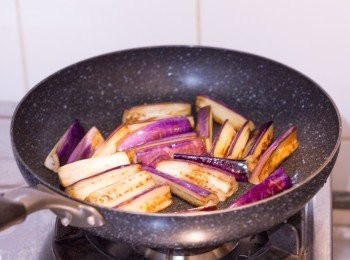 step4: 開中火，鍋子燒熱後下油至油可平鋪滿鍋底，油熱後下茄子，先煎帶皮那一面可令茄子保持形狀及顏色較紫。每面煎約 1 分鐘左右至半熟，煎好後盛起備用