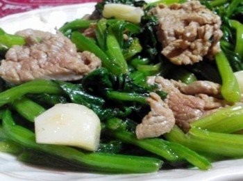 step2: 倒入橄欖油，把蒜頭放入鍋子爆香，再放入菲力牛肉小炒一下，接著放入菠菜一起炒，加入少許的米酒、塩、糖，最後加入少許香油，即可關火，呈盤上桌。