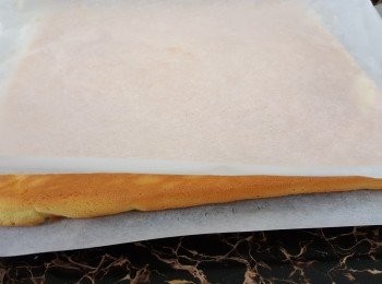 step13: 焗完將蛋糕片拎出，倒扣在鋪了牛油紙的鐵架上，再將蛋糕片上的牛油紙撕去，再蓋上牛油紙，放凉