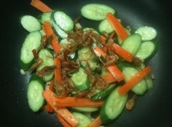 step3: 待聞到蒜油的香氣後（表示蒜油已經煉好了），放入步驟1的切片小黃瓜，再放入酥炸溪蝦，稍微拌炒一下，再從鍋邊淋上米酒，待酒精蒸發，就完成囉。