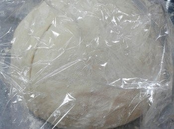 step5: 拿出麵糰，弄成自己喜歡的形狀（我做的是圓形）放在鋪了烘焙紙的盤上，再用保鮮紙蓋上，靜置約半小時，讓其作第二次發酵，麵糰會再脹大