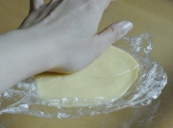 step9: 然後將 <span class="group_3">菠蘿外層</span>麵團分成8至10分，放一小份麵團在兩張保鮮紙中間，擀成圓形薄片（因麵團較黏，用保鮮紙較容易，也可用手壓平）