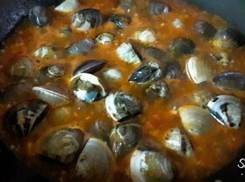 step3: 把蕃茄 , 蒜頭切碎 , 鍋子中加入2湯匙油燒熱後 , 加入蒜頭炒至香味出來 , 再加入蕃茄粒拌炒, 加入清水 , 蕃茄醬 , 糖 , 鹽煮滾 , 最後加入蛤蜊煮至打開 , 再加入羅勒 , 洋香菜煮一分鐘即可