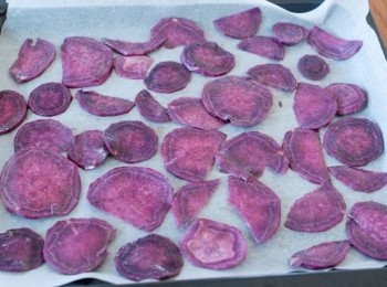 step2: 將蕃薯片放在鋪有烘焙紙的烤盤上，放入已預熱200度焗爐，焗10分鐘，然後將蕃薯反面，再焗15分鐘 （＊因蕃薯片的厚薄不同，焗爐火力不同，要小心觀察，如不脆，再焗長一點時間）