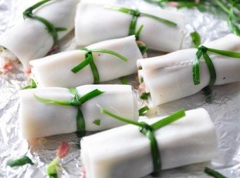 step2: 將粿仔片輕輕的緊緊的捲起來，並用韭菜做繩繞圈打結(新鮮韭菜較脆打結易斷，可將韭菜川燙變軟增加韌度)