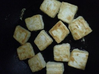 step4: 在平底鍋中，倒入油，開大火，待油四成熱時，將豆腐平放入鍋中，改小火將兩面都煎成金黃色。