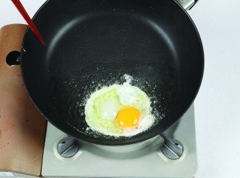 step2: 將食用油倒入寬口平底鍋，以大火熱鍋並把鍋子稍微往前傾，讓雞蛋在油鍋裡成半煎炸的狀態。