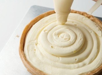 step11: 將10填入裝有直徑1㎝圓形擠花嘴的擠花袋中，擠在派塔的中間。分兩次擠，首先，從中心以畫螺旋的方式向外側擠出奶油，接著再次從中心向外以畫螺旋的方式擠奶油。邊緣要留點空間來裝飾草莓。