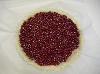 step7: ☞用叉子插ㄧ些小孔再放入冰箱30分後，取出，刷上些蛋白，舖上烘焙紙以及紅豆(或是米也可以)，入烤箱盲烤180度約20分鐘，取出後拿掉紅豆與烘焙紙，再刷ㄧ次蛋白入烤箱5分鐘。