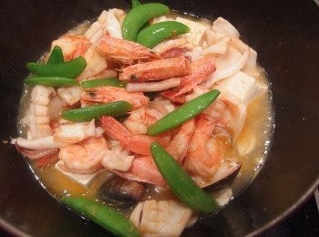 step7: 當蛤蜊煮開口時,最後放入剛才炒過的海鮮一起燴煮,再淋上太白粉水做勾芡,濃稠度可依個人喜好做調整,完成後起鍋盛入砂鍋再加入一匙XO干貝醬裝飾即可。