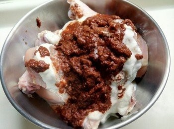 step2: 首先雞下腿洗淨，用廚紙抹乾水份，在雞肉表面鎅兩刀（可入味d）。將乳酪及 Tandoori Paste 加入，拌勻。