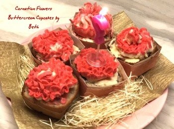 step11: 切掉部份杯子蛋糕頂部使扁變平，可以再塗上剩下奶油奶酪，自冰箱取出康乃馨花，去除烘培紙，放在杯子蛋糕上即可