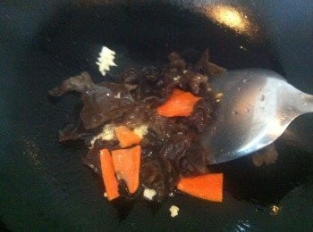 step6: 熱鍋，倒適量食用油，下蒜末爆香、倒進木耳、胡蘿蔔大火爆炒片刻。