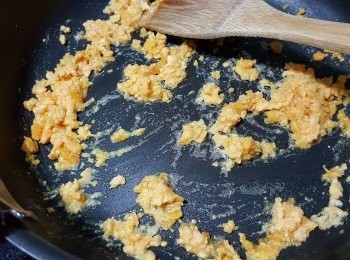 step6: 落咸蛋黃碎用中火加約2湯匙水炒到蛋黃起泡