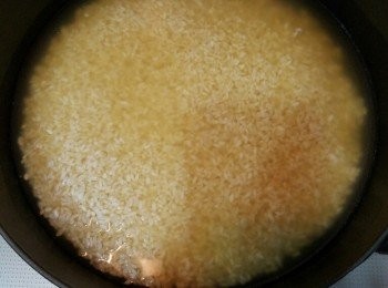 step2: 米洗好，用同等分量的冬菇蝦干及瑤柱水，放鐵鑄鍋開始煲飯。中火煲飯，至開始有收水的現象。