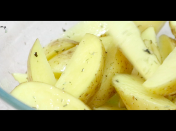 step2: 把橄欖油／植物油、鹽、雜香草和黑胡椒碎撒在馬鈴薯角上，攪均。