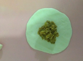 step6: 將光滑一面做面，放入豬肉餡，一邊折一邊轉，最後捏緊收口。