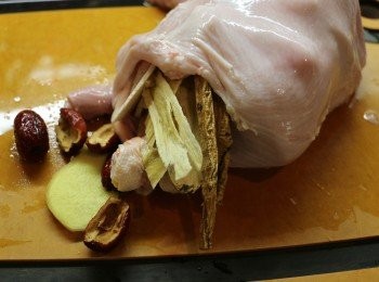 step6: 然後將整只雞塞進豬肚內，再放入一半紅棗、黨蔘、北芪、淮山、薑片和1包白胡椒，做成一個肚包雞樣子。（沒有茶包袋，直接將白胡椒粒放進去。）