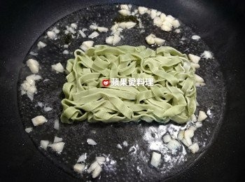 step3: 聞到蒜香時，倒入一碗水，放入菠菜義大利麵，蓋鍋蓋，燜30秒。