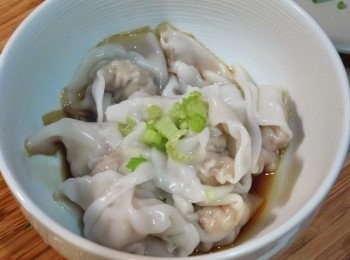 step5: 在碗裡放進一小匙醬油及糖、麻油少許，就是一個簡易的無辣醬料，如果喜歡吃辣的人可以放入辣油，餛飩放進碗內，再撒上芹菜末或蔥花增添香氣，即完成。