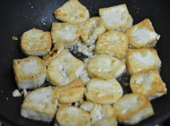 step1: 一大匙油熱鍋後，將切塊的豆腐放入香煎，再灑入蒜末一起香煎到兩面金黃