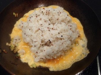 step5: 加入冷飯,快炒翻動米飯及蛋汁,炒出蛋香味,再加入海鹽及黑胡椒粉做調味。秘訣之一:利用蛋汁包覆米飯,在拌炒過程中米飯裡如果釋出水份,就會馬上被蛋汁包覆住,經過翻炒即可讓米飯粒粒分明不結塊也不黏鍋。