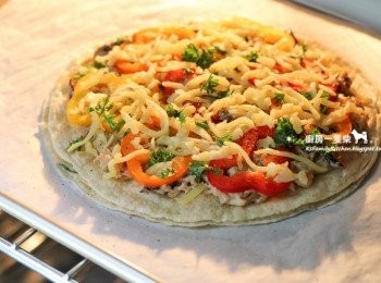 step9: 最後撒上適量起司絲，送入預熱至200度C(約400度F)的烤箱中，烘烤約5~10分鐘，至起司融化、呈現金黃烤色即可。

**若家中沒有合適的烤箱可操作，也可直接在平底鍋中完成餅皮跟餡料的堆疊動作，最後蓋上鍋蓋，以中小火慢慢將起司絲加熱融化