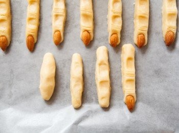step4: 取出麵糰後，(1)先揉成長條狀，(2)接著稍微整型，(3)然後壓出關節的痕跡，(4)最後用牛排刀畫出指痕並放上杏仁。(如圖示從左至右。)