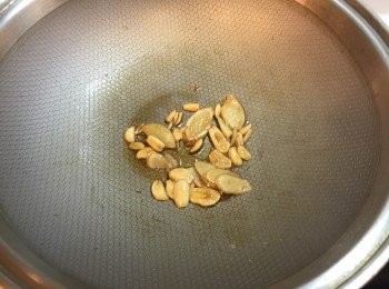 step3: 鍋中放入麻油以小火爆香薑片、蒜片，約2分鐘
