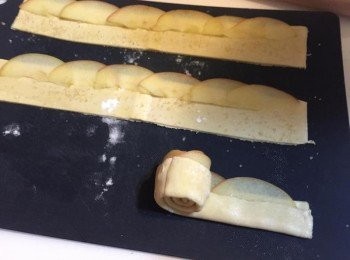 step5: 接著撒上少許肉桂粉, 再將下部份約1/3的酥皮往上對折, 並從一端開始慢慢捲起來